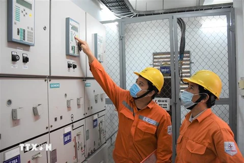 Các công nhân EVNHANOI kiểm tra độ an toàn của lưới điện. (Ảnh: TTXVN phát)