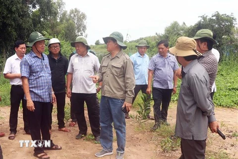 Chủ tịch UBND tỉnh Cà Mau Huỳnh Quốc Việt (áo xanh, trái) lắng nghe ý kiến của ngành chức năng về việc đầu tư, hoàn thiện một dự án tái định cư cho người dân ven biển Tây. (Ảnh: Huỳnh Anh/TTXVN)