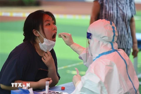Nhân viên y tế lấy mẫu xét nghiệm COVID-19 cho người dân tại tỉnh An Huy, Trung Quốc ngày 16/7/2022. (Ảnh: THX/TTXVN)