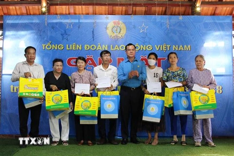 Ông Nguyễn Đình Khang, Chủ tịch Tổng liên đoàn Lao động Việt Nam trao quà và 5 triệu tiền mặt cho thân nhân các liệt sĩ đã hy sinh tại trận chiến đấu bảo vệ đảo Gạc Ma tại huyện Cam Lâm. (Ảnh: Phan Sáu/TTXVN)