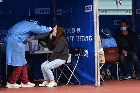 Nhân viên y tế lấy mẫu xét nghiệm COVID-19 cho người dân tại Hong Kong, Trung Quốc. (Ảnh: AFP/TTXVN)