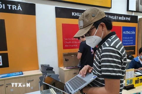 Khách hàng lựa chọn mua laptop tại một cửa hàng điện máy trên địa bàn thành phố Bà Rịa. (Ảnh: Hoàng Nhị/TTXVN)