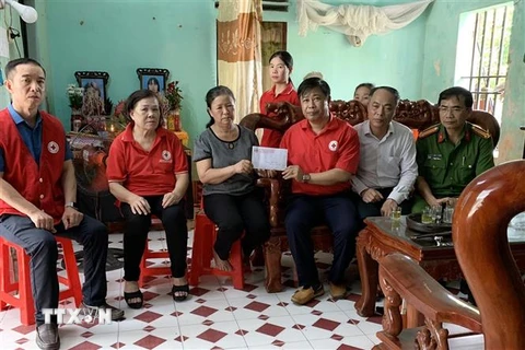 Lãnh đạo Hội Chữ thập đỏ tỉnh Nam Định, Hội Chữ thập đỏ thành phố Nam Định trao tiền ủng hộ gia đình nạn nhân. (Ảnh: TTXVN phát)