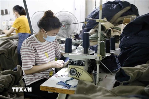 Sản xuất hàng may mặc xuất khẩu sang Hàn Quốc tại Công ty TNHH May mặc Hồng Quang. (Ảnh: Trần Việt/TTXVN)