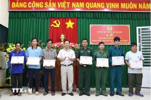 Lãnh đạo huyện An Phú, tỉnh An Giang trao tặng Giấy khen cho 6 người dân có thành tích xuất sắc trong phong trào Toàn dân bảo vệ An ninh Tổ quốc. (Ảnh: TTXVN phát)