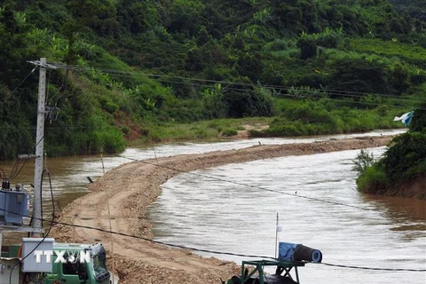 Công ty TNHH 87 tự ý dùng phương tiện cơ giới mở lòng đường ra giữa sông để tiến hành khai thác cát ở thôn 7, xã Đăk Pxi, huyện Đăk Hà, tỉnh Kon Tum. (Ảnh: Cao Nguyên/TTXVN)