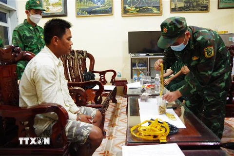 Đối tượng Chau Rít Mây cùng tang vật khi bị bắt giữ. (Ảnh: TTXVN phát)