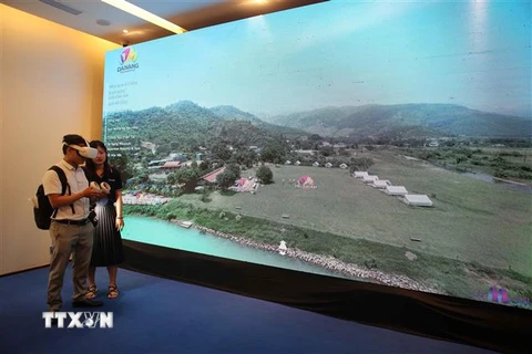 Người dân trải nghiệm du lịch Đà Nẵng từ ứng dụng “Một chạm đến Đà Nẵng” trên công nghệ VR360 tại chương trình. (Ảnh: Trần Lê Lâm/TTXVN)