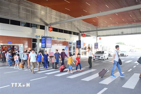 Hành khách di chuyển đến điểm đỗ để đón xe tại Cảng hàng không quốc tế Cam Ranh. (Ảnh: TTXVN phát)