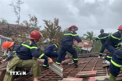 Lực lượng chức năng hỗ trợ người dân tại Thừa Thiên-Huế lợp lại mái nhà sau bão số 4. (Ảnh: Tường Vi/TTXVN)