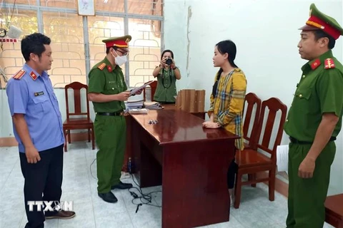 Lực lượng chức năng đọc lệnh bắt tạm giam đối với Ninh Thị Vân Anh. (Ảnh: TTXVN phát)
