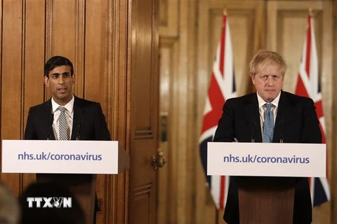 Ông Boris Johnson (phải), khi đang giữ chức Thủ tướng Anh, và Bộ trưởng Tài chính Rishi Sunak tại cuộc họp báo ở London ngày 17/3/2020. (Ảnh: AFP/TTXVN)