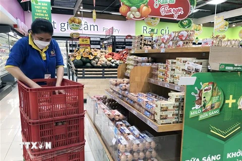 Nhân viên siêu thị Thành phố Hồ Chí Minh cung ứng hàng hóa lên quầy, kệ phục vụ người dân mua sắm. (Ảnh: Mỹ Phương/TTXVN)