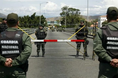 Quân đội Venezuela và Colombia đứng gác tại biên giới giữa hai nước. (Ảnh: Reuters)