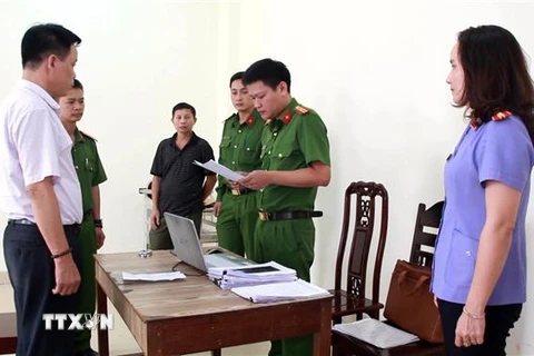 Cơ quan Cảnh sát điều tra Công an tỉnh Nghệ An đọc lệnh bắt tạm giam Lê Văn Bình. (Ảnh: TTXVN phát)