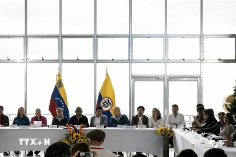 Các thành viên phái đoàn Chính phủ Colombia (phải) và nhóm vũ trang Quân đội Giải phóng Quốc gia (ELN - trái) tại cuộc họp báo sau vòng đàm phán hòa bình ở Caracas, Venezuela, ngày 21/11/2022. (Ảnh: AFP/TTXVN)