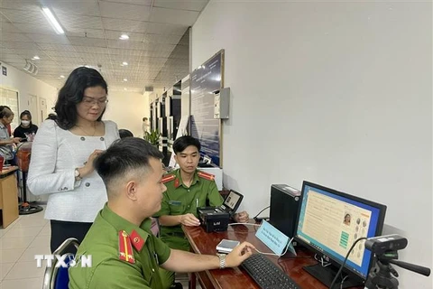 Lực lượng công an hướng dẫn cho người dân sử dụng dịch vụ công trực tuyến. (Ảnh: Huyền Trang/TTXVN)