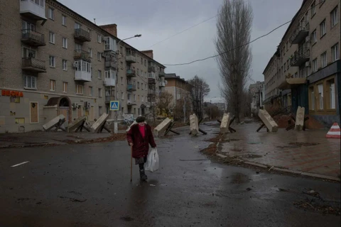 Một người phụ nữ đi bộ qua các công sự trên đường phố Ukraine. (Nguồn: The New York Times)