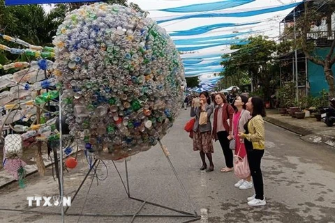 Các du khách thăm quan sản phẩm tại Festival nghệ thuật sắp đặt môi trường biển Hội An 2022. (Ảnh: Đoàn Hữu Trung/TTXVN)