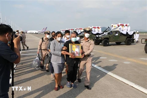 Người thân của các thủy thủ thiệt mạng trong vụ chìm tàu HTMS Sukhothai mang ảnh người thân tại tỉnh Rayong, Thái Lan, ngày 22/12/2022. (Ảnh: AFP/TTXVN)
