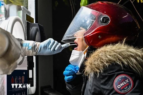 Nhân viên y tế lấy mẫu xét nghiệm COVID-19 cho người dân tại Thượng Hải, Trung Quốc ngày 23/12/2022. (Ảnh: AFP/TTXVN)