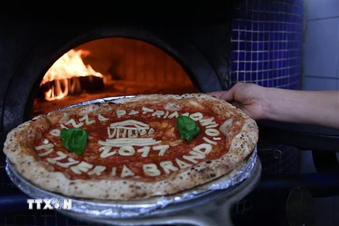 Chế biến Pizza tại một nhà hàng ở Naples, Italy. (Ảnh: AFP/TTXVN)