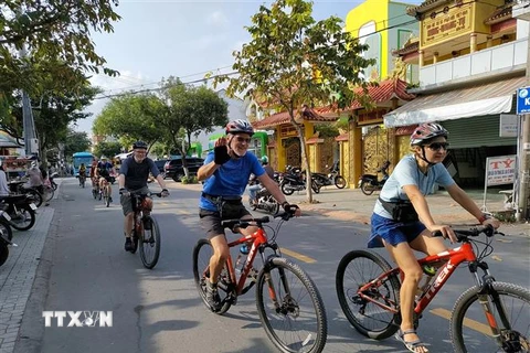 Du khách nước ngoài đi xe đạp trải nghiệm tại thành phố Bến Tre. (Ảnh: Huỳnh Phúc Hậu/TTXVN)