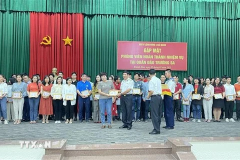 Nhà báo Nguyễn Cúc (TTXVN) nhận Huy hiệu Chiến sỹ Trường Sa. (Ảnh: TTXVN phát)