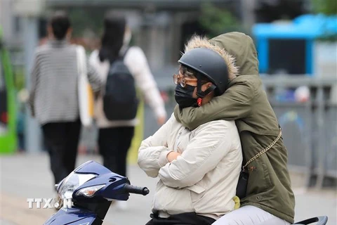Người dân phải mặc ấm khi ra đường. (Ảnh: Thanh Tùng/TTXVN)