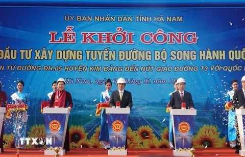 Các đại biểu bấm nút Khởi công Dự án đầu tư xây dựng tuyến đường bộ song hành Quốc lộ 21, tại xã Khả Phong, huyện Kim Bảng. (Ảnh: Thanh Tuấn/TTXVN)