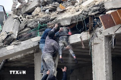 Giải cứu một em nhỏ ra khỏi đống đổ nát sau trận động đất ở thành phố Afrin, tỉnh Aleppo, Syria ngày 6/2/2023. (Ảnh: AFP/TTXVN)