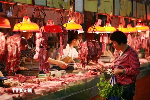 Người dân mua thực phẩm tại một khu chợ ở Quảng Châu, tỉnh Quảng Đông, Trung Quốc. (Ảnh: AFP/TTXVN)