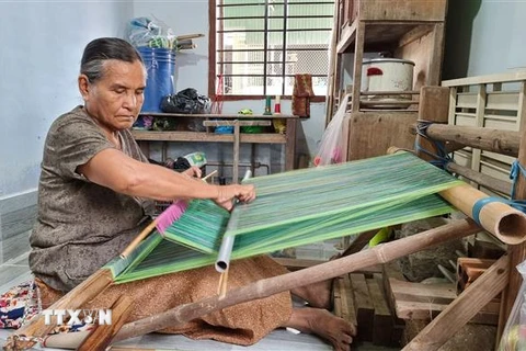 Nghệ nhân lớn tuổi người Chăm dệt vải thổ cẩm truyền thống. (Ảnh: Nguyễn Thành/TTXVN)
