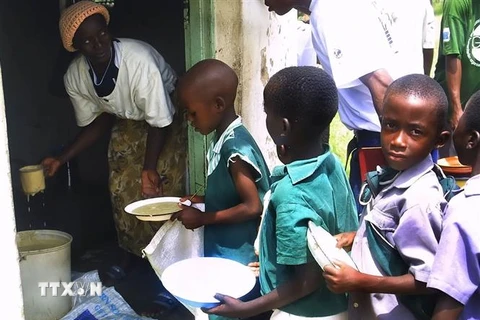Trẻ em xếp hàng nhận bữa ăn do Chương trình Lương thực Thế giới tài trợ tại Harare, Zimbabwe. (Ảnh: AFP/TTXVN)