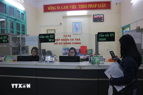 Người dân thực hiện các thủ tục hành chính tại bộ phận "Một cửa" phường Quán Thánh, quận Ba Đình. (Ảnh Mạnh Khánh/TTXVN)