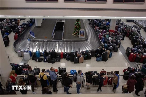 Hành khách bị mắc kẹt do hủy chuyến bay chờ đợi tại khu vực lấy hành lý của Hãng hàng không Southwest Airlines ở sân bay Midway, Chicago, Illinois, Mỹ, ngày 27/12/2022. (Ảnh: AFP/TTXVN)