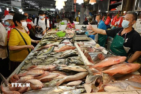 Người tiêu dùng mua sắm tại khu chợ ở Singapore. (Ảnh: AFP/TTXVN)