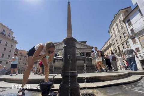 Người dân uống nước giải nhiệt tại một đài phun nước ở Rome, Italy ngày 6/8/2022 trong thời tiết nắng nóng. (Ảnh: AFP/TTXVN)