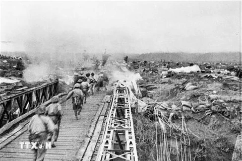 Bộ đội ta vượt qua cầu Mường Thanh, tấn công vào Sở chỉ huy Tập đoàn cứ điểm Điện Biên Phủ, chiều 7/5/1954. (Ảnh: Tư liệu TTXVN)