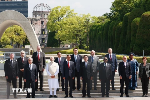 Thủ tướng Phạm Minh Chính cùng Trưởng đoàn các nước khách mời chụp ảnh chung trước Đài tưởng niệm Nạn nhân vụ nổ bom nguyên tử tại Công viên Tưởng niệm hòa bình Hiroshima. (Ảnh: Dương Giang/TTXVN)