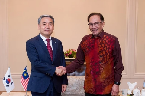 Bộ trưởng Quốc phòng Hàn Quốc Lee Jong-sup (trái) bắt tay Thủ tướng Malaysia Anwar Ibrahim trong cuộc gặp ở Langkawi, Malaysia ngày 24/5. (Nguồn: Yonhap)