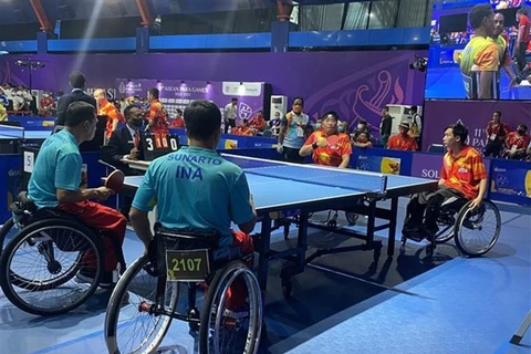 Cặp tay vợt của Đội tuyển bóng bàn khuyết tật Việt Nam thi đấu với đối thủ Indonesia tại ASEAN Para Games 11, Indonesia. (Ảnh: Hữu Chiến-Văn Phong/TTXVN)