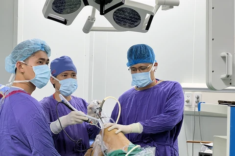 Các bác sỹ bệnh viện Việt Đức phẫu thuật nội soi tái tạo dây chằng chéo trước khớp gối hai bên cùng lúc cho thanh niên 17 tuổi ở Hà Nội. (Nguồn: Báo Đại biểu Nhân dân)