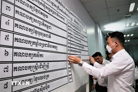 Nhân viên NEC niêm yết kết quả xếp thứ tự 18 chính đảng tham gia tổng tuyển cử năm 2023. (Ảnh: Huỳnh Thảo/ TTXVN)