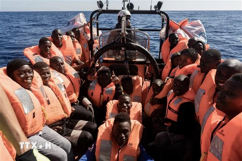 Người di cư chuẩn bị lên tàu Ocean Viking tại hải phận quốc tế, ngoài khơi Libya trên Địa Trung Hải, sau khi được giải cứu bởi tổ chức nhân đạo quốc tế của châu Âu, ngày 3/11/2022. (Ảnh: AFP/TTXVN)