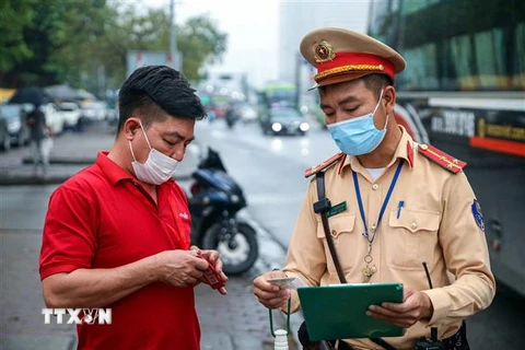 Một trường hợp xe khách đón trả khách sai quy định bị lực lượng CSGT dừng xe, kiểm tra và lập biên bản. (Ảnh: Phạm Kiên/TTXVN)