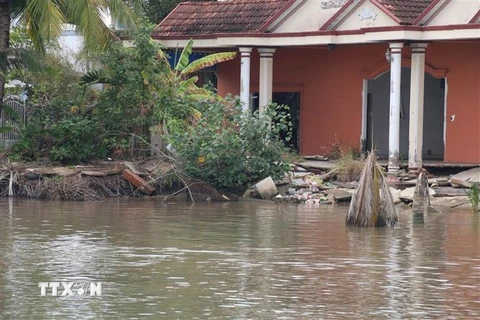 Một nhà dân ở Tiền Giang bị sụp xuống sông do ảnh hưởng của biến đổi khí hậu. (Ảnh: Minh Trí/TTXVN)