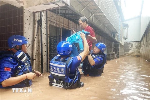 Nhân viên cứu hộ sơ tán người dân khỏi các khu vực ngập lụt ở Trùng Khánh, Trung Quốc, ngày 4/7/2023. (Ảnh: THX/TTXVN)