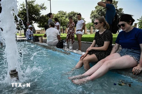 Người dân tránh nóng tại đài phun nước ở Thessaloniki , Hy Lạp, ngày 14/7/2023. (Ảnh: AFP/TTXVN)