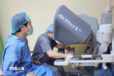 Bác sỹ Philippines điều khiển robot dưới sự hướng dẫn của bác sĩ Nguyễn Phú Hữu, Bệnh viện Bình Dân. (Ảnh: TTXVN phát)